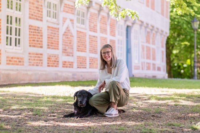 Sabrina Haake mit ihrem Hund vor dem historischen Fachwerkgebäude in Osterholz-Scharmbeck